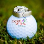 Desert Willow golf course logo on golf ball, beneath set of wedding rings