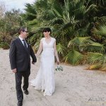 bride and groom walking on the sand 