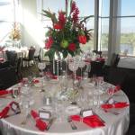 Red flowers and napkins banquet table setting