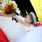 small flower girl wearing flower crown, reaching for bouquet