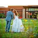 Bride and groom kissing outside of reception hall