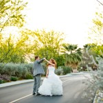 Groom spinning bride while walking down golf course path 