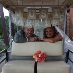 Bride and groom on a golf course with a "Just Married" sign
