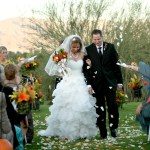 Bride and groom just married recessional with petals of flowers tossed around them