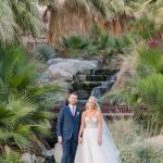 Bride and groom posing in front of waterfall on golf course 