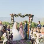 Bride and groom during wedding ceremony with light purple flower petals down the aisle