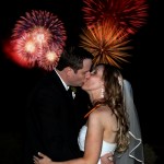 Bride and groom kiss during fireworks