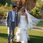 Bride and groom walking hand in hand on golf course