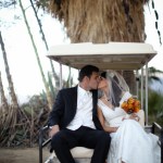 Bride and groom kissing on the back of a golf cart