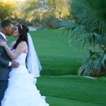 Bride and groom kissing on golf course green