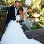 Groom holding a bride while bride lifts her arm in celebration