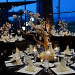 Banquet table seating with candles and flowers on centerpiece shaped like a Bonsai tree