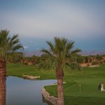 Landscape view of bride and groom walking on golf course 