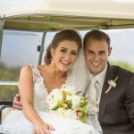 Bride and groom smiling on golf cart