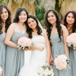 Bridal party in mint green dresses with bride holding white flowers 