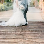 Bride and groom on wooden bridge on golf course