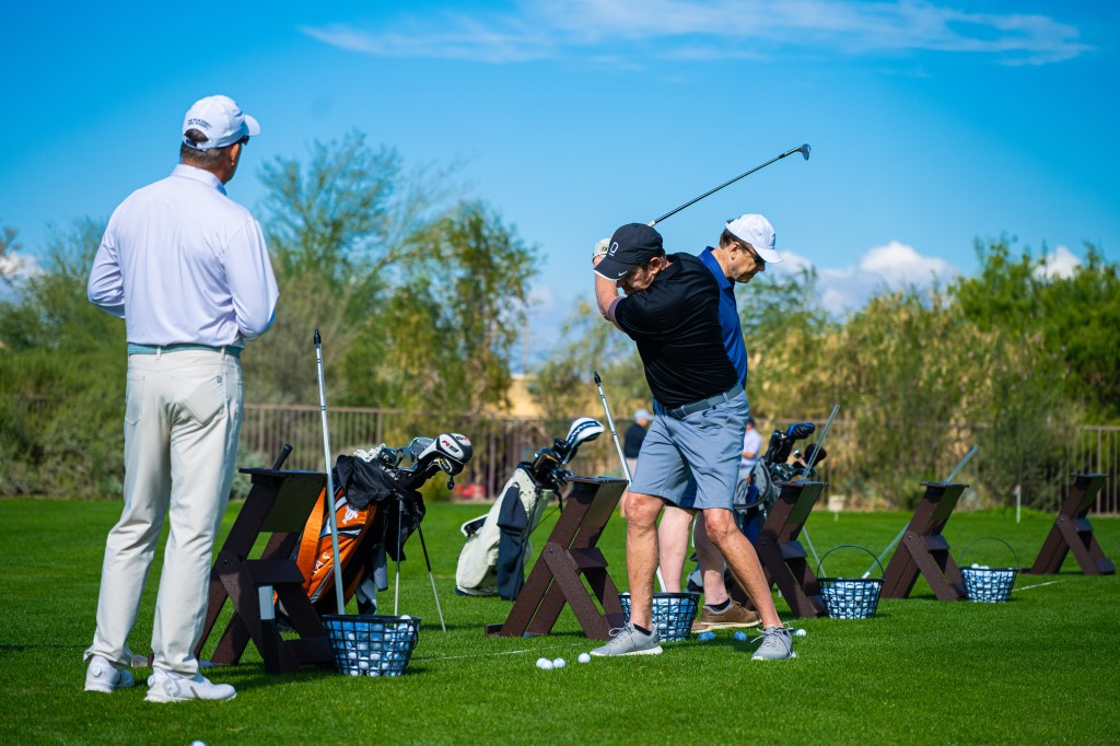 PGA instructor coaching golfers on the practice range at Desert Willow Golf Resort during the 2-Day Signature Golf School, with students practicing swings under professional guidance.