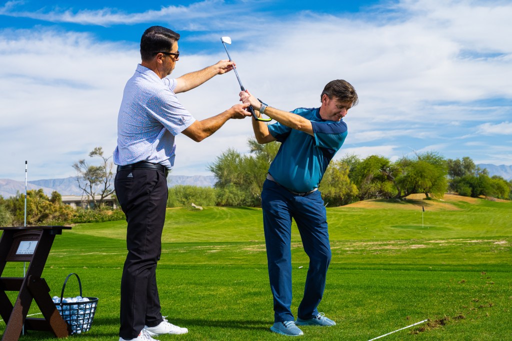 Private golf lesson card at Palm Desert Golf Academy showing a PGA Professional providing one-on-one instruction to a student on the practice range, with lesson details for the 50-minute Individual session priced at $175.