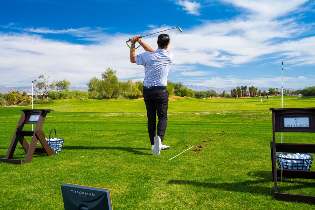 Golfer practicing on the all-grass driving range with unlimited golf balls at Desert Willow Golf Resort.