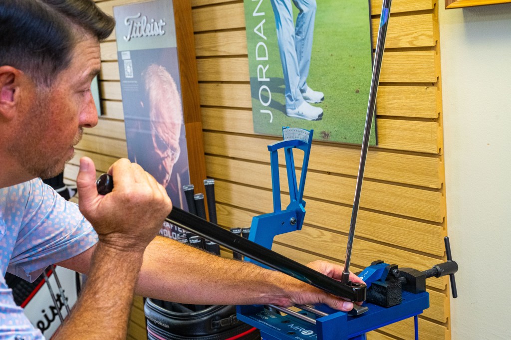 PGA professional performing a custom club fitting at the Palm Desert Golf Academy at Desert Willow Golf Resort, adjusting a golf club with precision equipment inside the fitting studio.