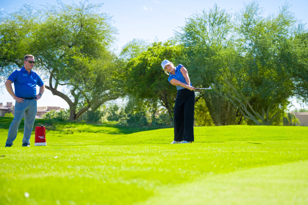 Short Game lesson card at Palm Desert Golf Academy showing golfers practicing chipping and pitching on the practice green, promoting an 80-minute session focused on short game fundamentals and consistency.