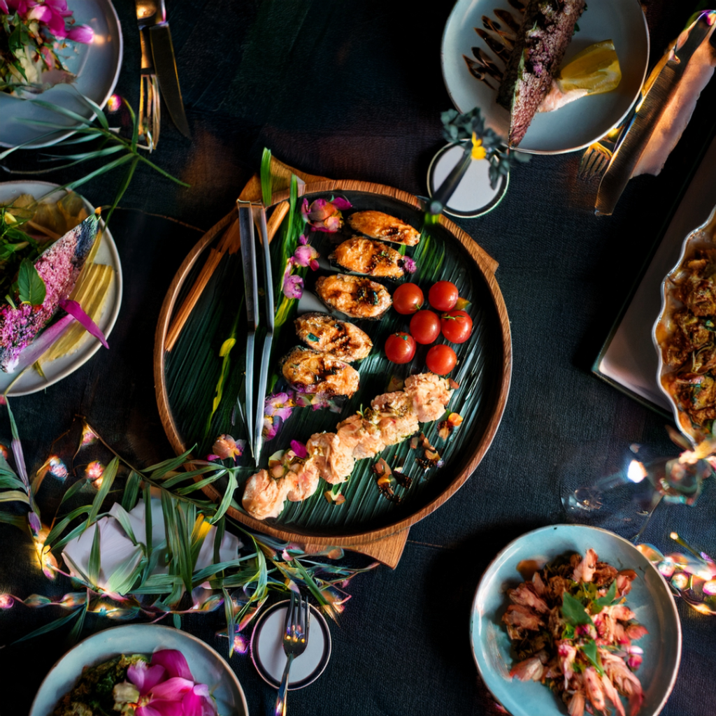 A colorful chef-curated buffet spread with seafood skewers, fresh vegetables, and artistic plating, representing music-inspired menus at Desert Willow’s Music & Dining Under the Stars.